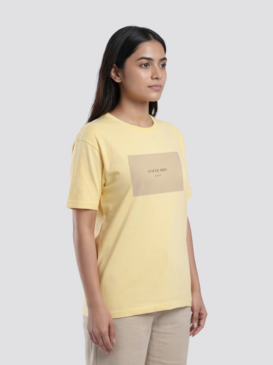 Woman wearing a yellow t-shirt with a logo on a white background