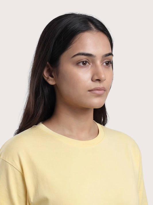 Woman wearing a yellow shirt against a plain background