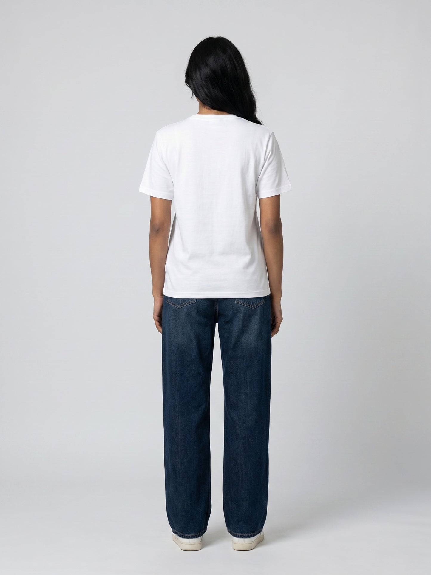 Back view of white Keos cotton t-shirt styled with blue denim jeans, showing clean regular fit and minimal everyday styling.