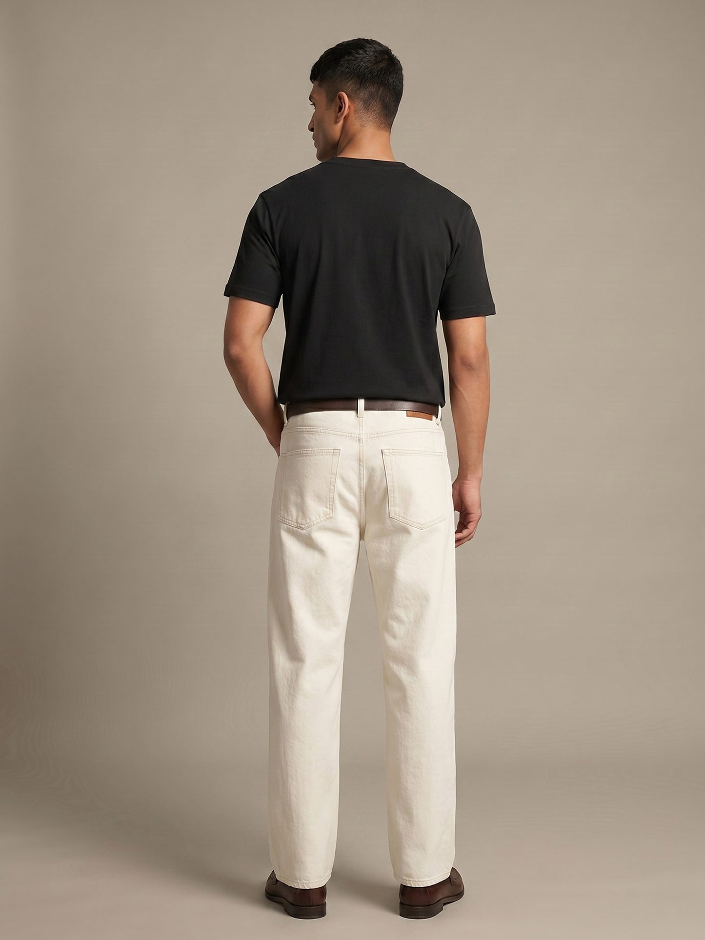 Back view of black Keos cotton t-shirt styled with off-white denim, showing clean regular fit and minimal everyday menswear look.
