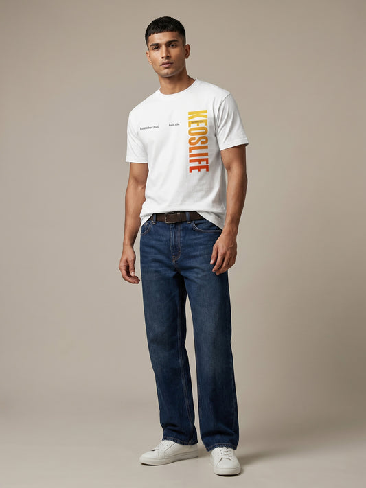 Keos Pride Month special white cotton graphic t-shirt for men, featuring vertical KEOSLIFE gradient print with blue jeans and white sneakers.