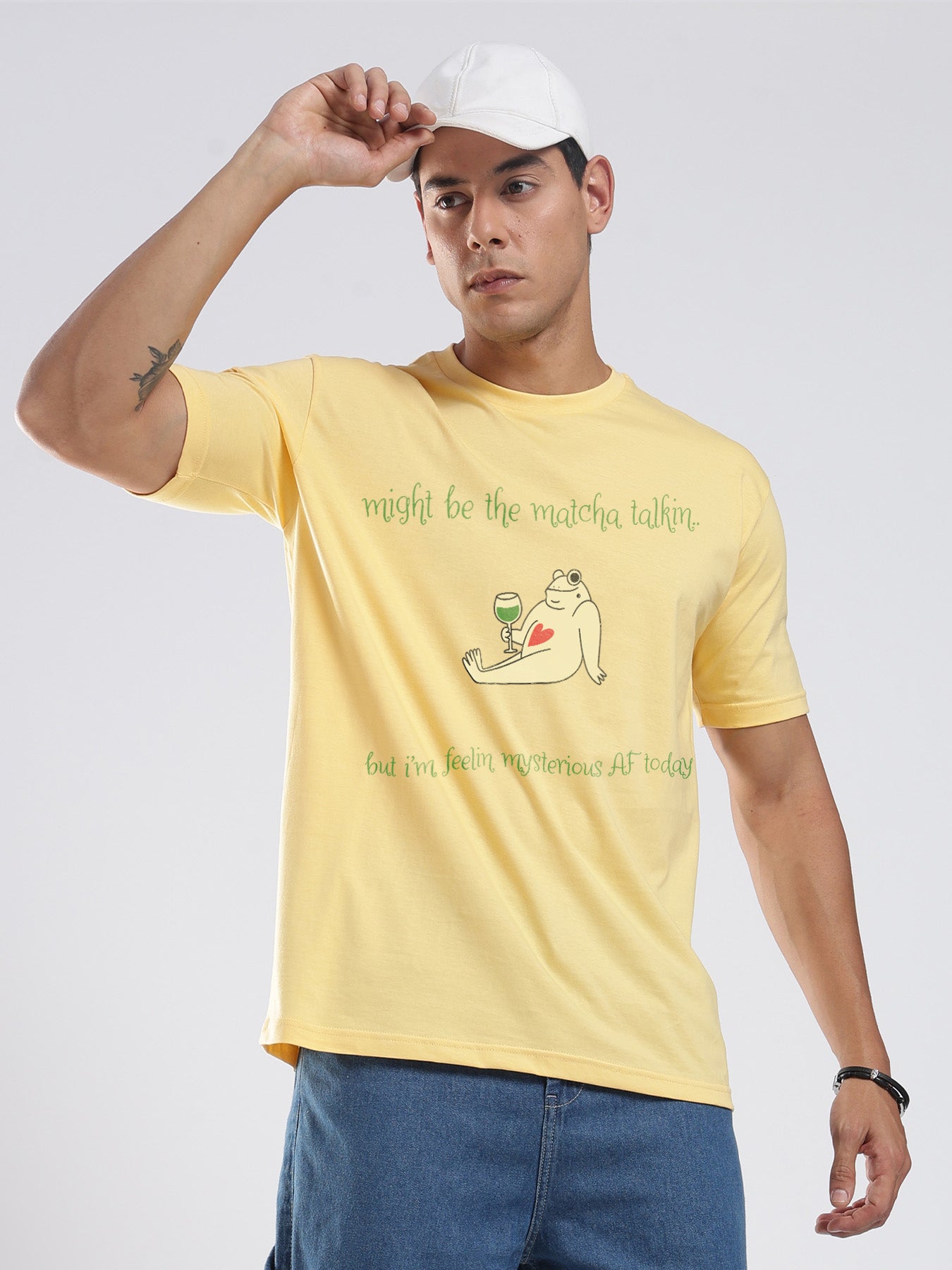 Person wearing a yellow t-shirt with a graphic and text on a plain background