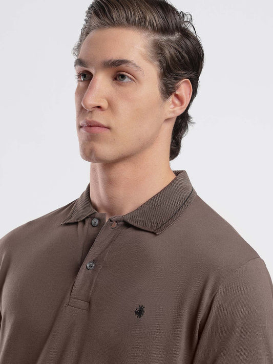 Man wearing a brown KEOS polo shirt with a visible brand logo on a white background