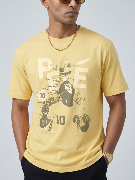 Man wearing a yellow butter colour t-shirt with a graphic of PELÈ the footballer in it