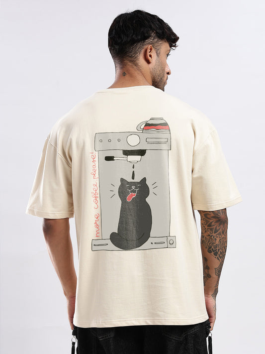 Person wearing a beige t-shirt with a graphic of a cat and a coffee machine on the back.