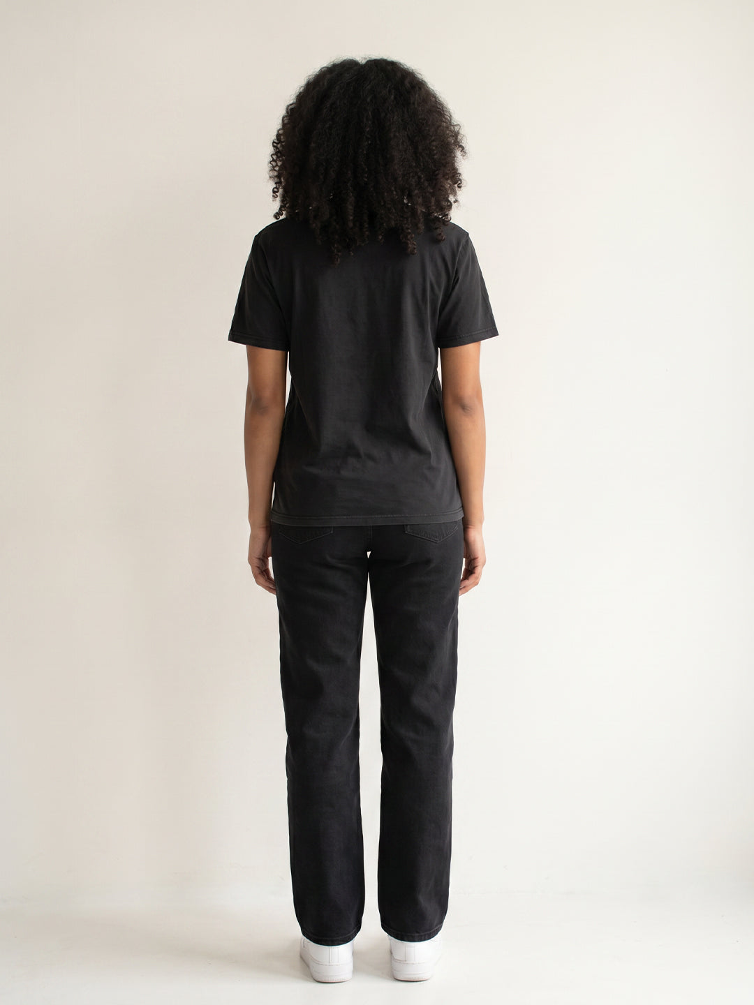 Person wearing a black t-shirt and black pants on a white background