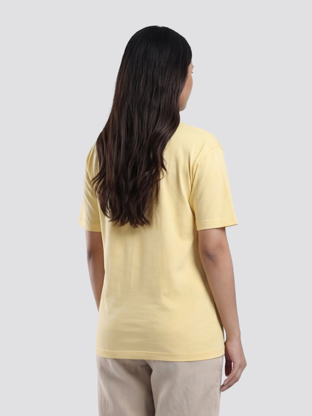 Person wearing a yellow t-shirt on a plain background