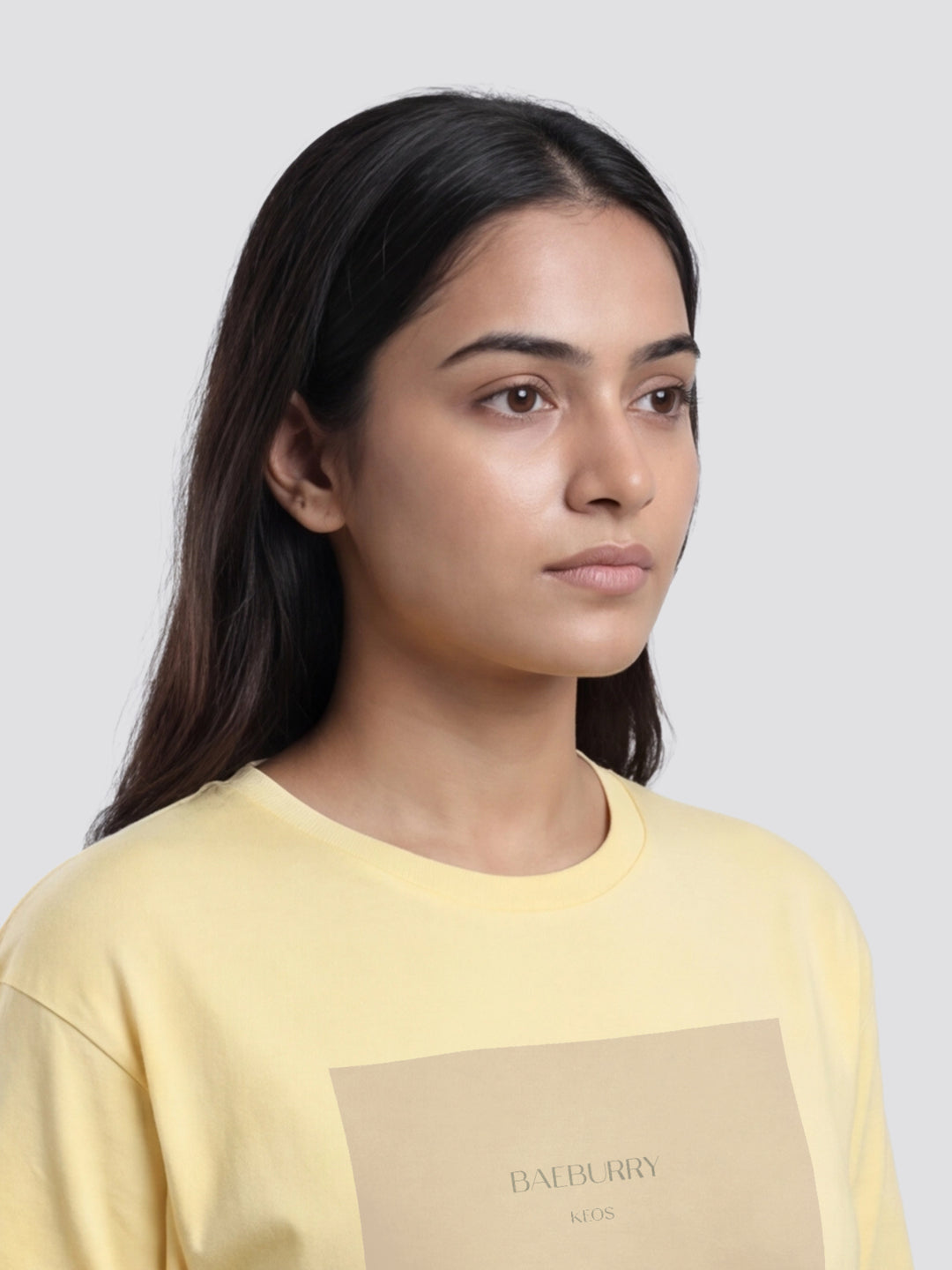 Woman wearing a yellow Burberry sweatshirt against a plain background