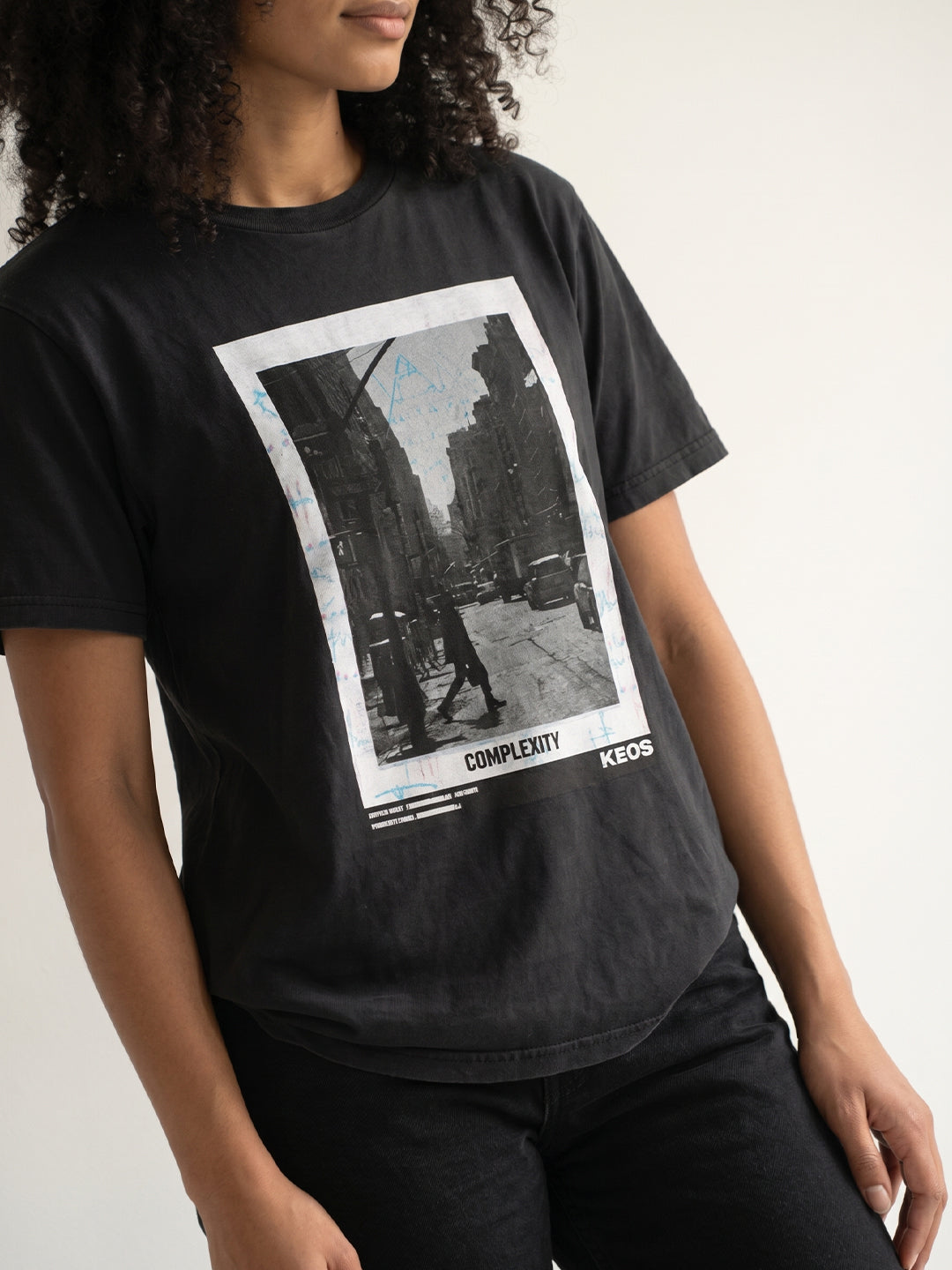 Person wearing a black t-shirt with a graphic design and text