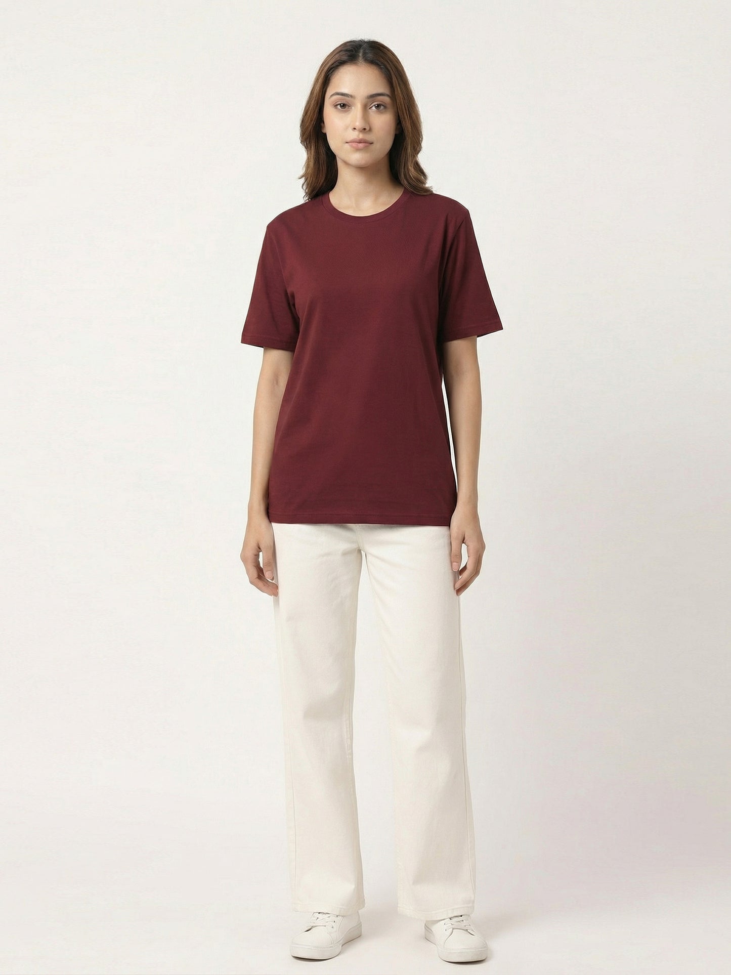 Person wearing a maroon t-shirt and white pants on a white background