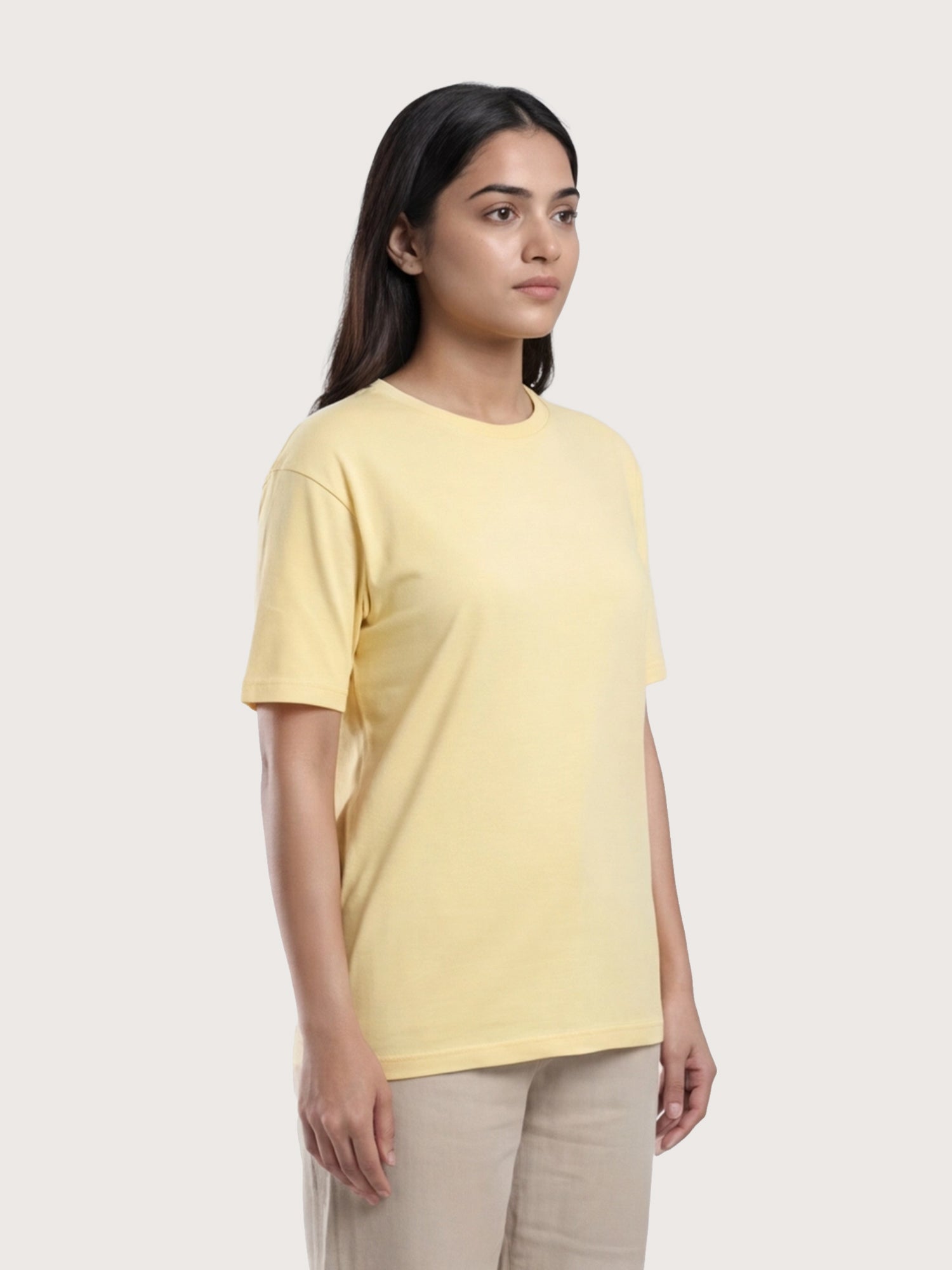 Woman wearing a yellow t-shirt against a plain background
