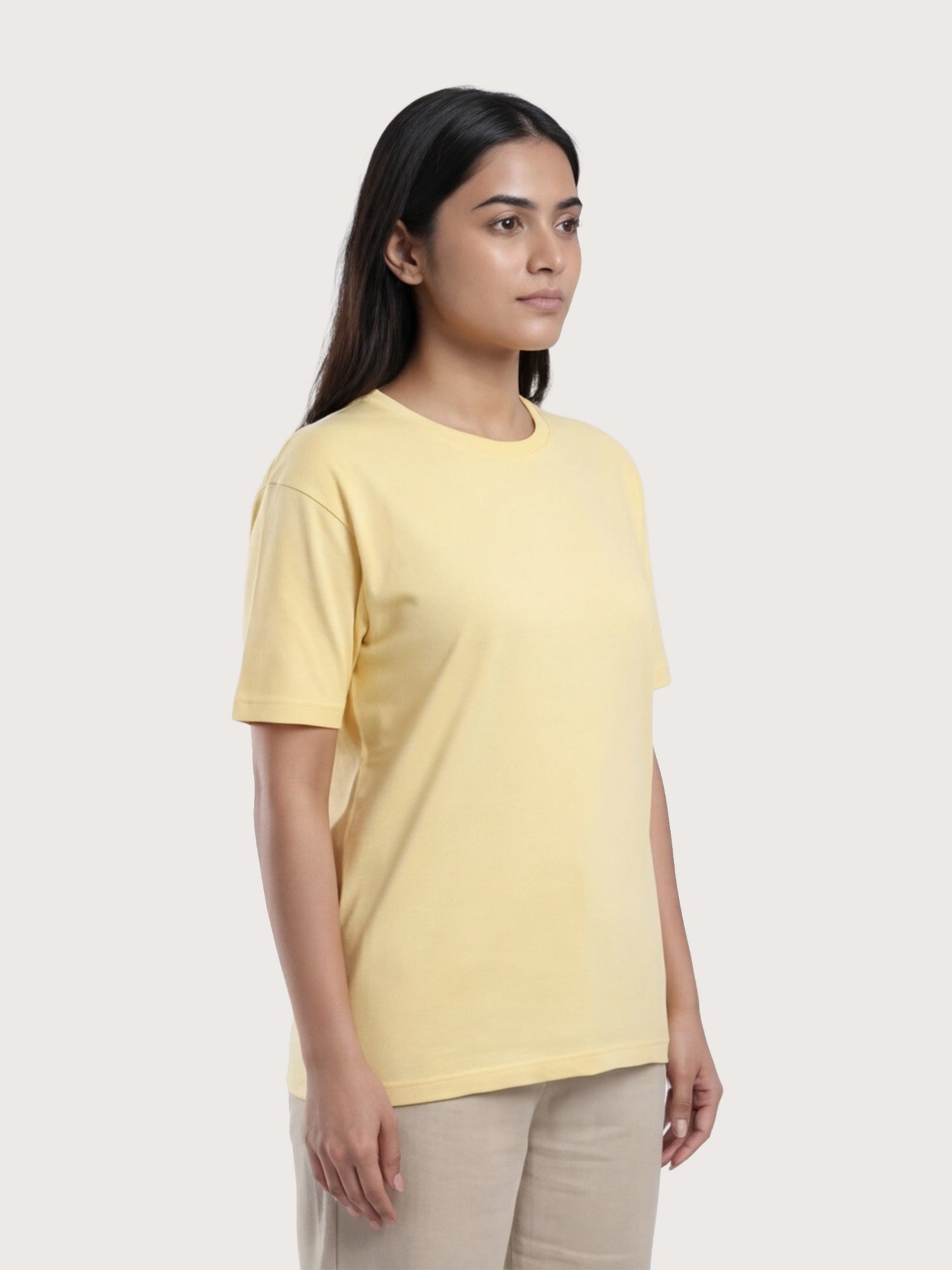 Woman wearing a yellow t-shirt against a plain background