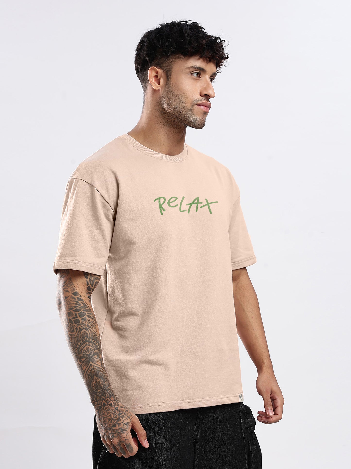 Man wearing a beige t-shirt with 'Relax' text on a white background