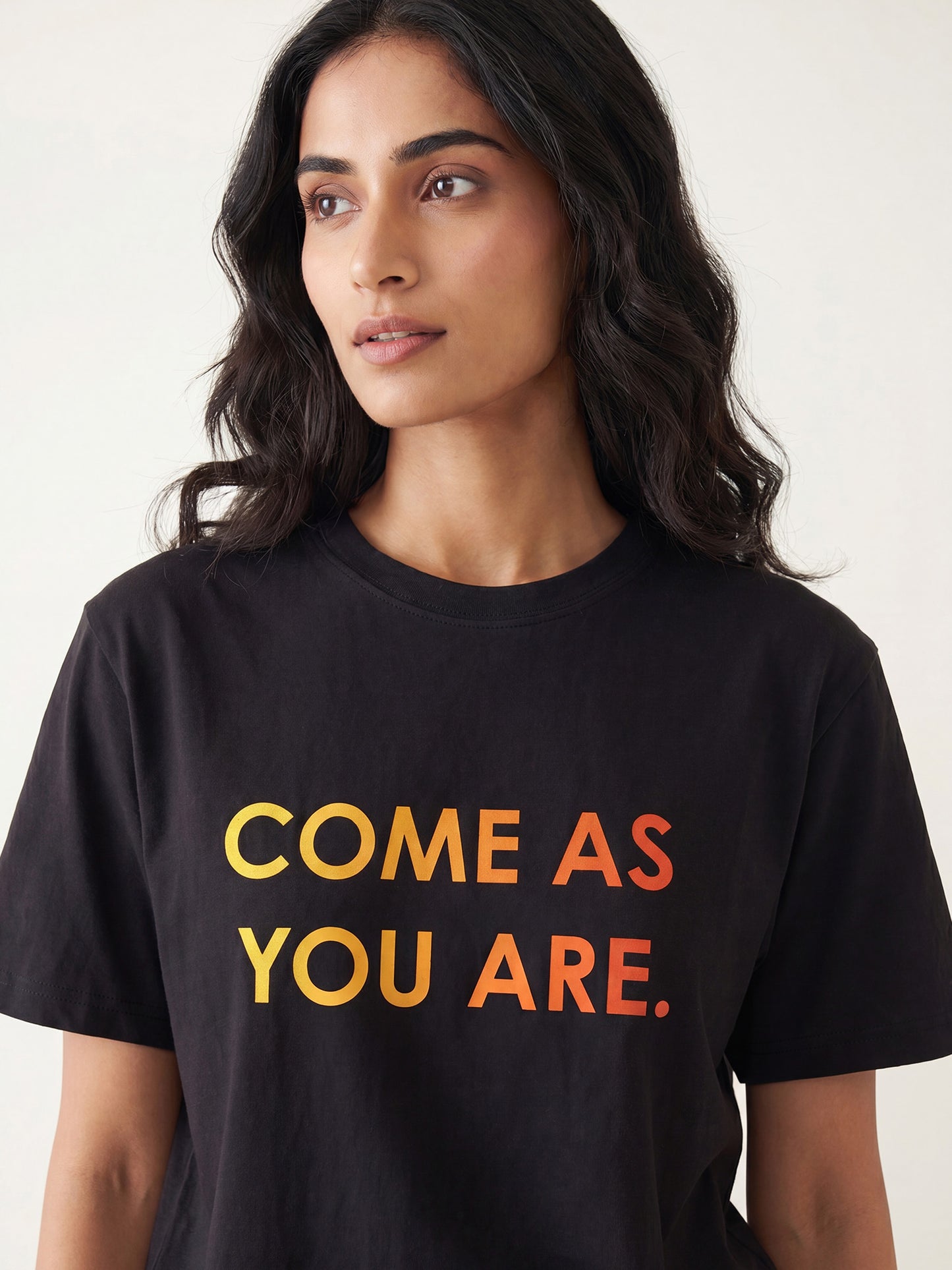 Close-up of Keos Come As You Are black cotton t-shirt showing yellow orange statement print, crew neck, half sleeves, and soft fabric texture.