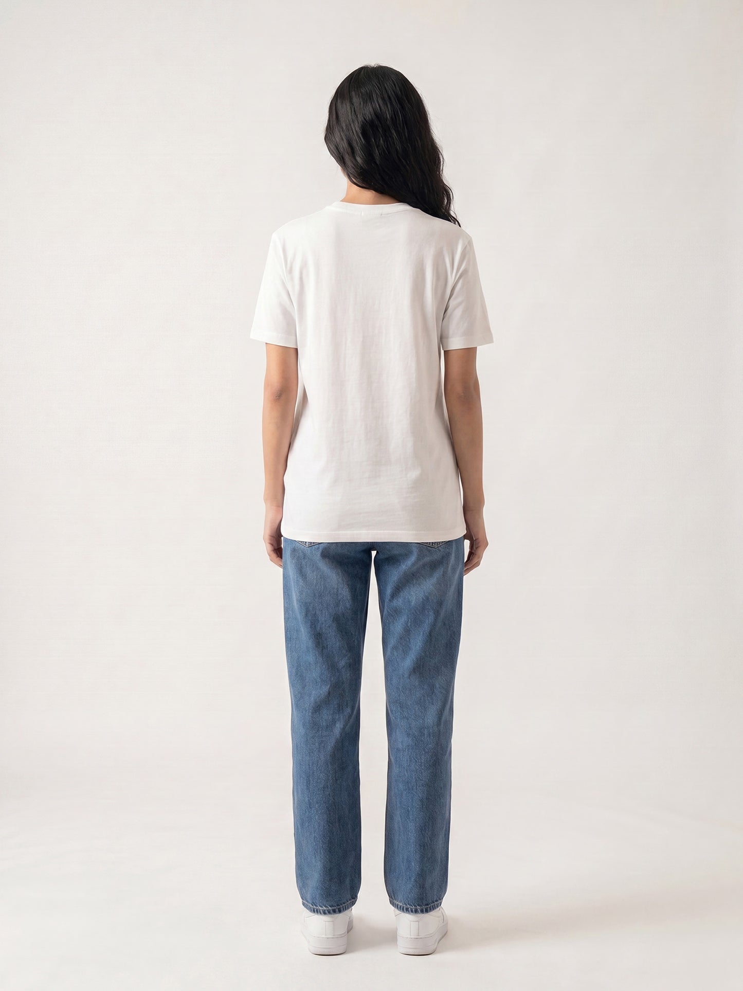 Back view of white Keos cotton t-shirt styled with blue denim jeans, showing clean regular fit and minimal everyday styling.
