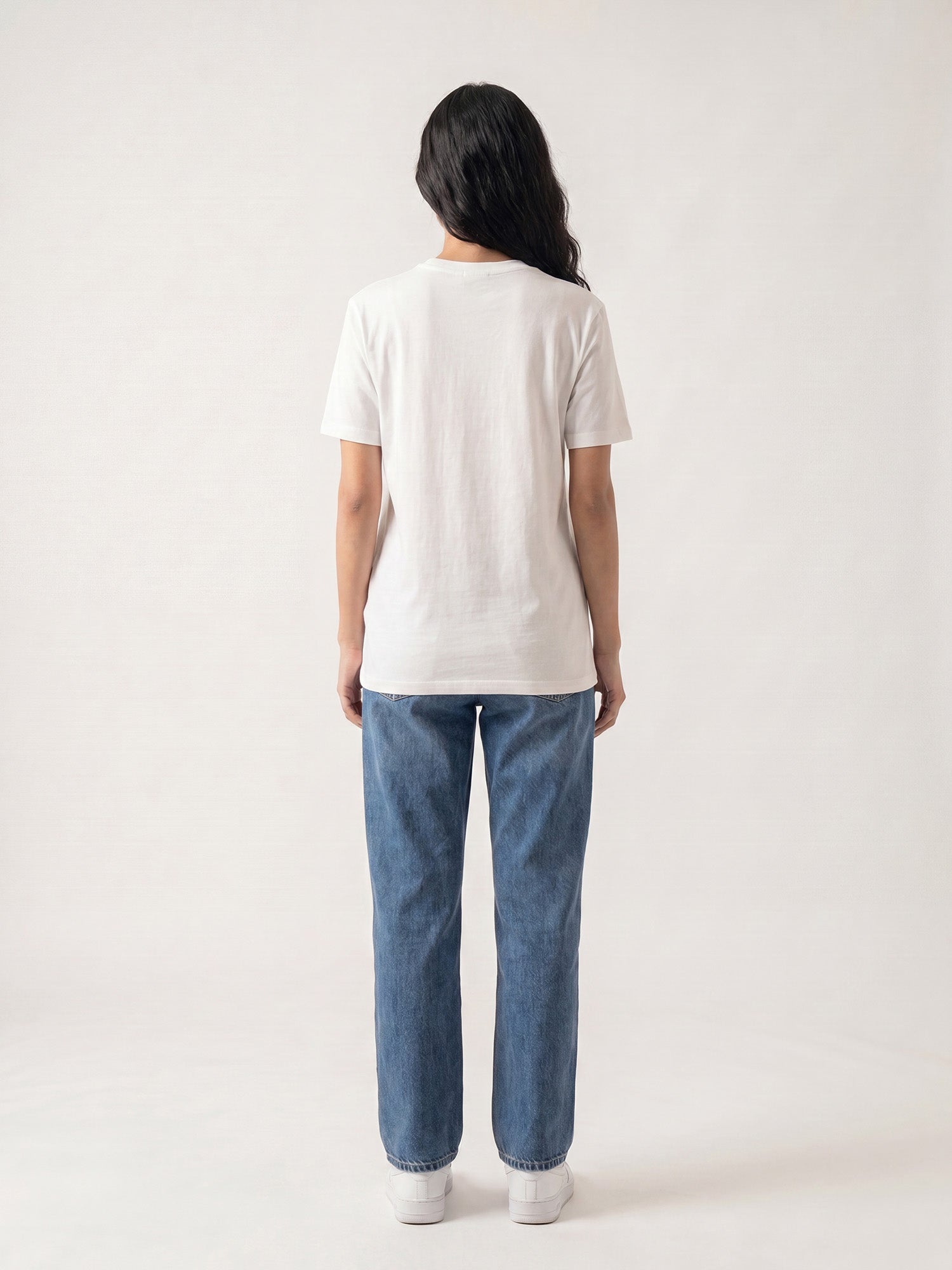 Back view of white Keos cotton t-shirt styled with blue denim jeans, showing clean regular fit and minimal everyday styling.