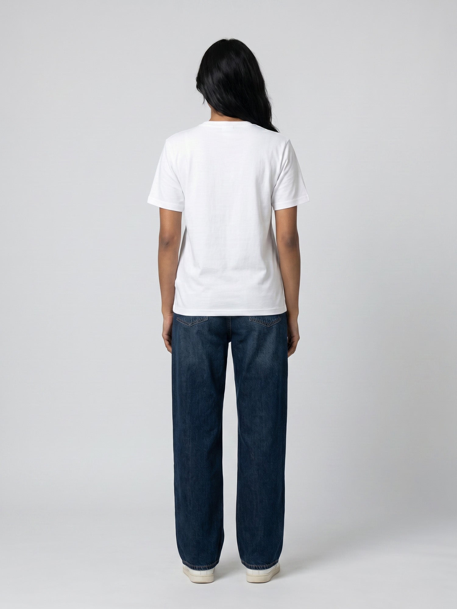 Back view of white Keos cotton t-shirt styled with blue denim jeans, showing clean regular fit and minimal everyday styling.