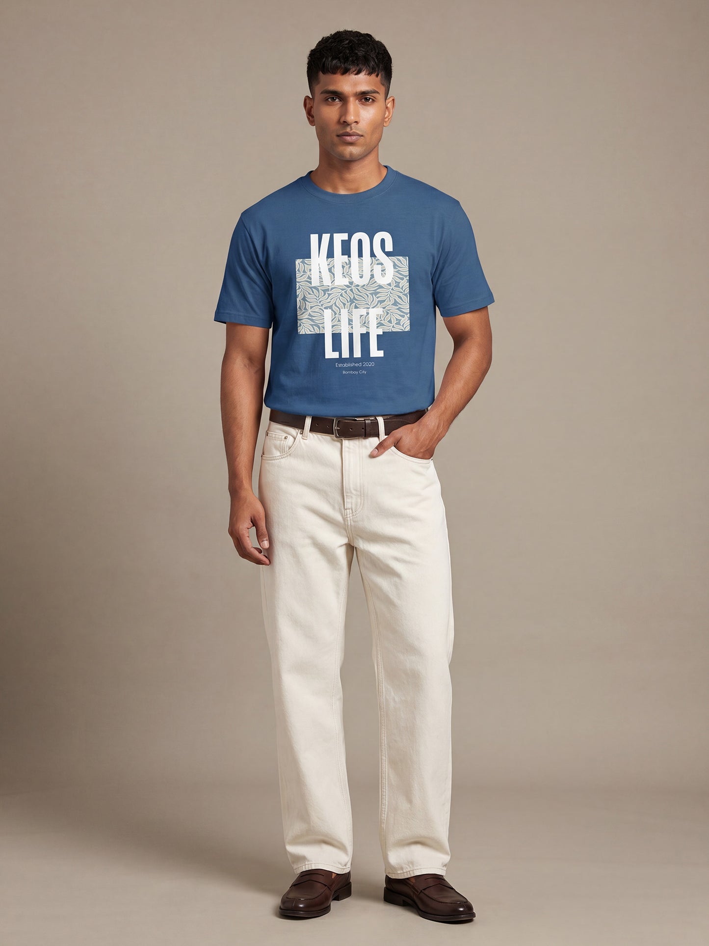 Keos blue cotton graphic t-shirt for men featuring white KEOS LIFE floral block print, styled with off-white denim and brown loafers.
