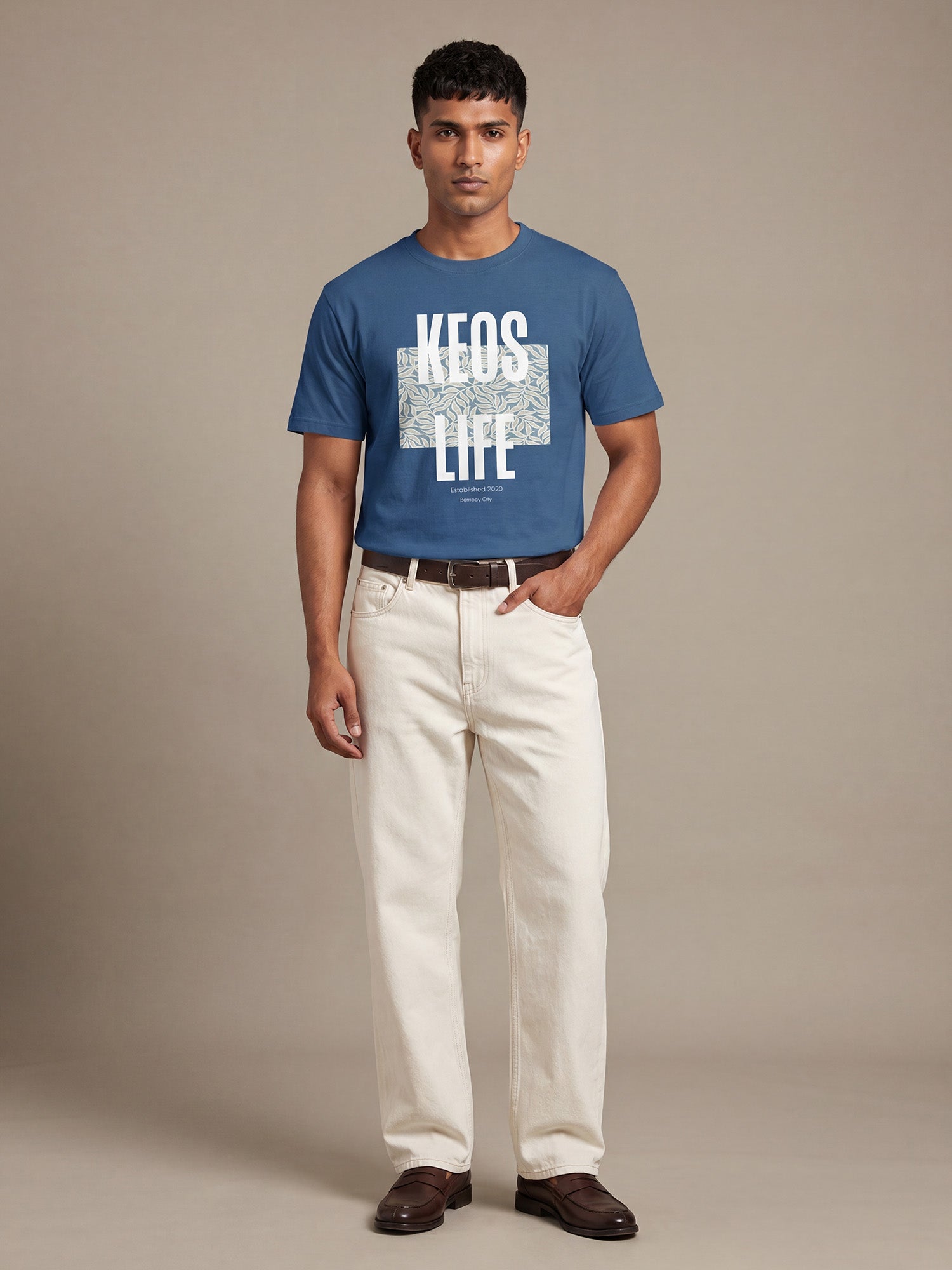 Keos blue cotton graphic t-shirt for men featuring white KEOS LIFE floral block print, styled with off-white denim and brown loafers.