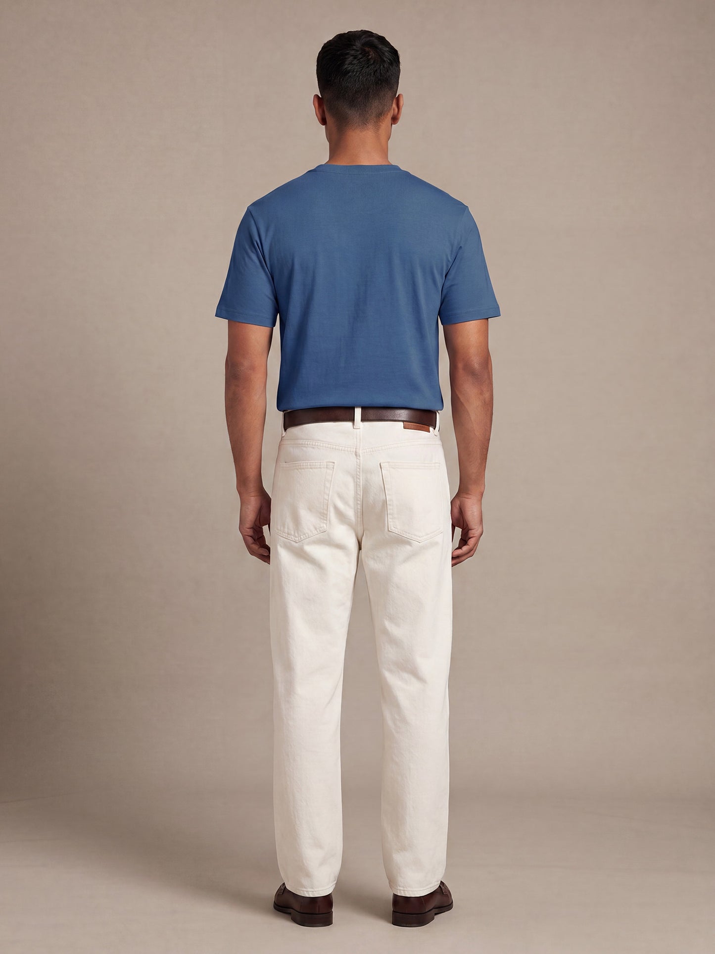 Back view of blue Keos cotton t-shirt styled with off-white denim, showing clean regular fit and minimal everyday menswear styling.