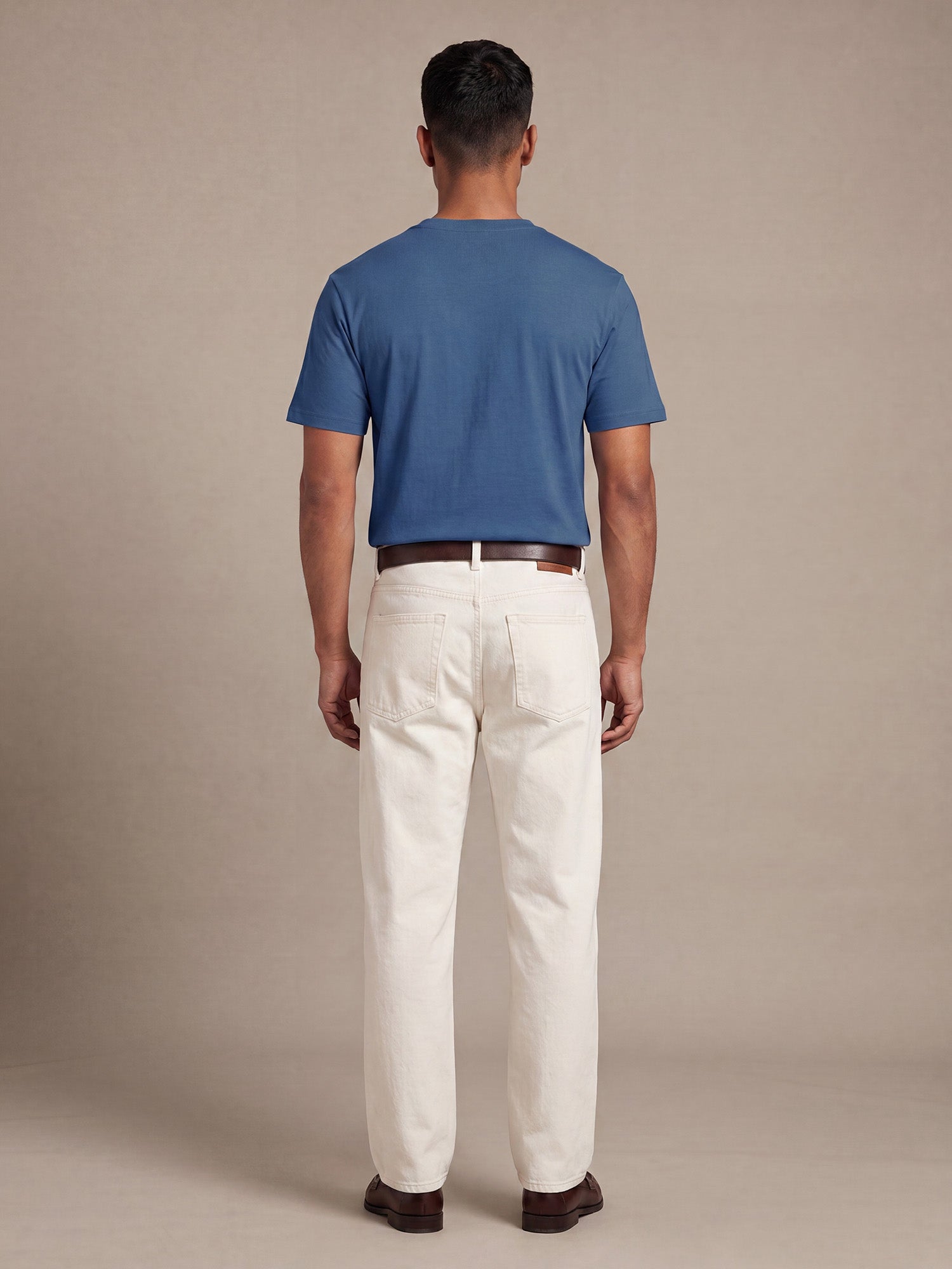 Back view of blue Keos cotton t-shirt styled with off-white denim, showing clean regular fit and minimal everyday menswear styling.