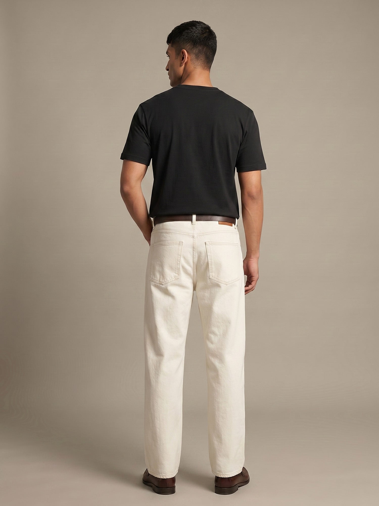 Back view of black Keos cotton t-shirt styled with off-white denim, showing clean regular fit and minimal everyday menswear look.