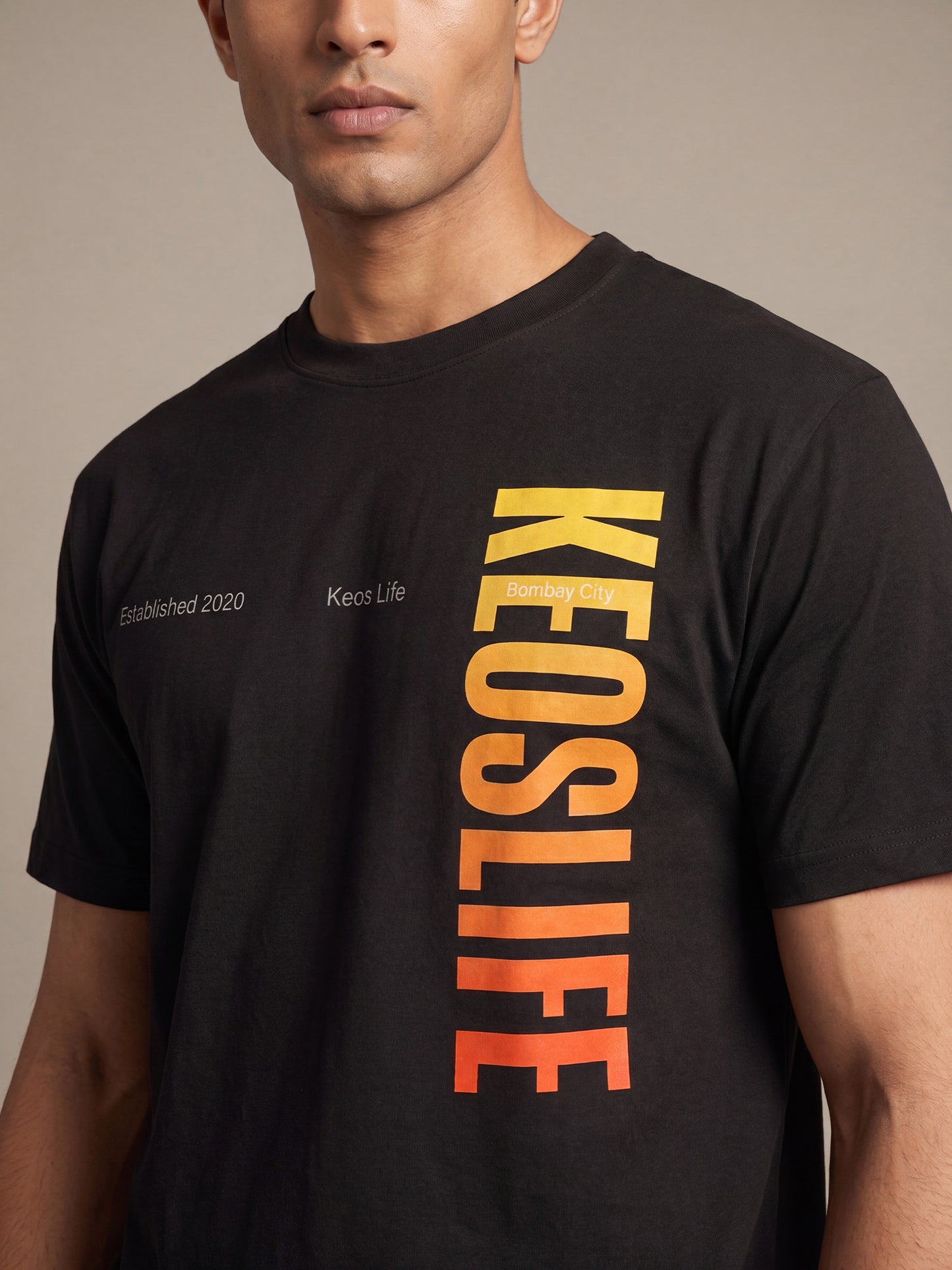 Close-up of Keos Pride Bold black cotton t-shirt showing vertical KEOSLIFE gradient graphic print, crew neck, and soft fabric texture.