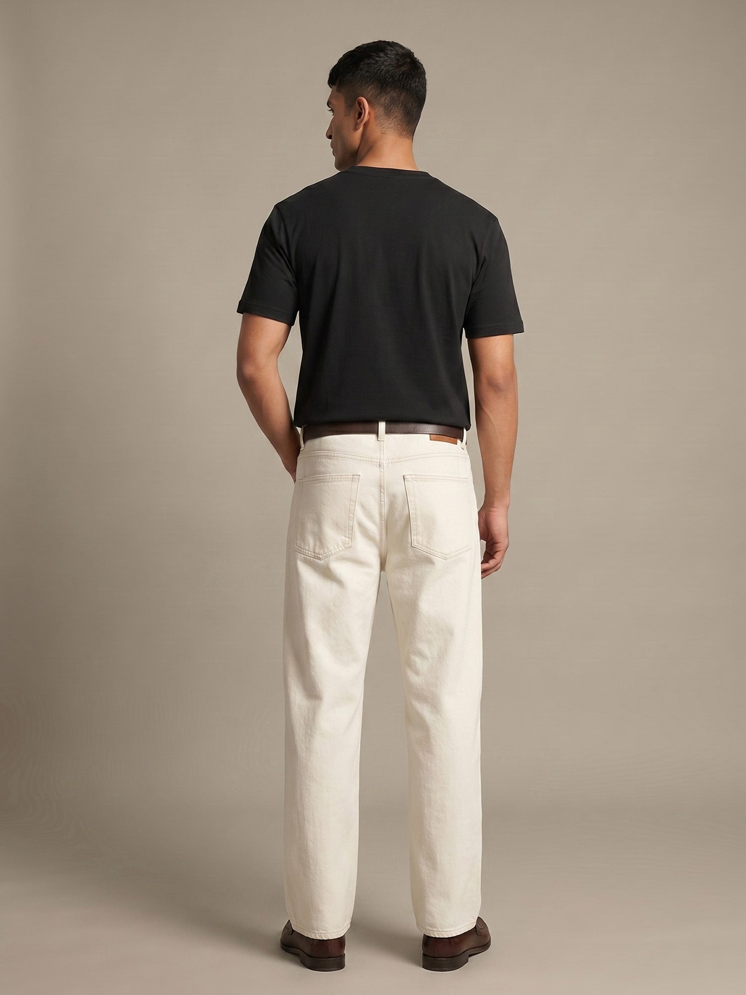 Back view of black Keos cotton t-shirt styled with off-white denim, showing clean regular fit and minimal everyday menswear styling.