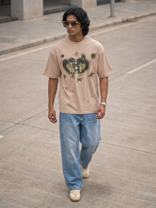 Pink Fate Off Script Graphic T-Shirt Keos oversized blush pink graphic t-shirt paired with relaxed light wash denim and white sneakers. A modern streetwear look featuring artistic graphics, statement sunglasses and effortless city style, blending casual fashion, oversized silhouettes and contemporary self-expression.