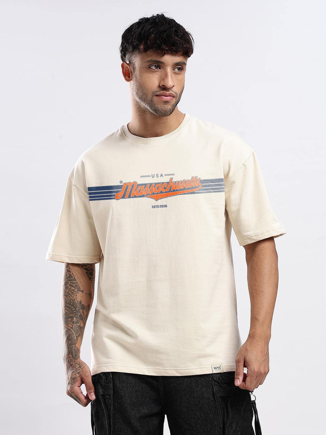 Man wearing a beige t-shirt with text on it