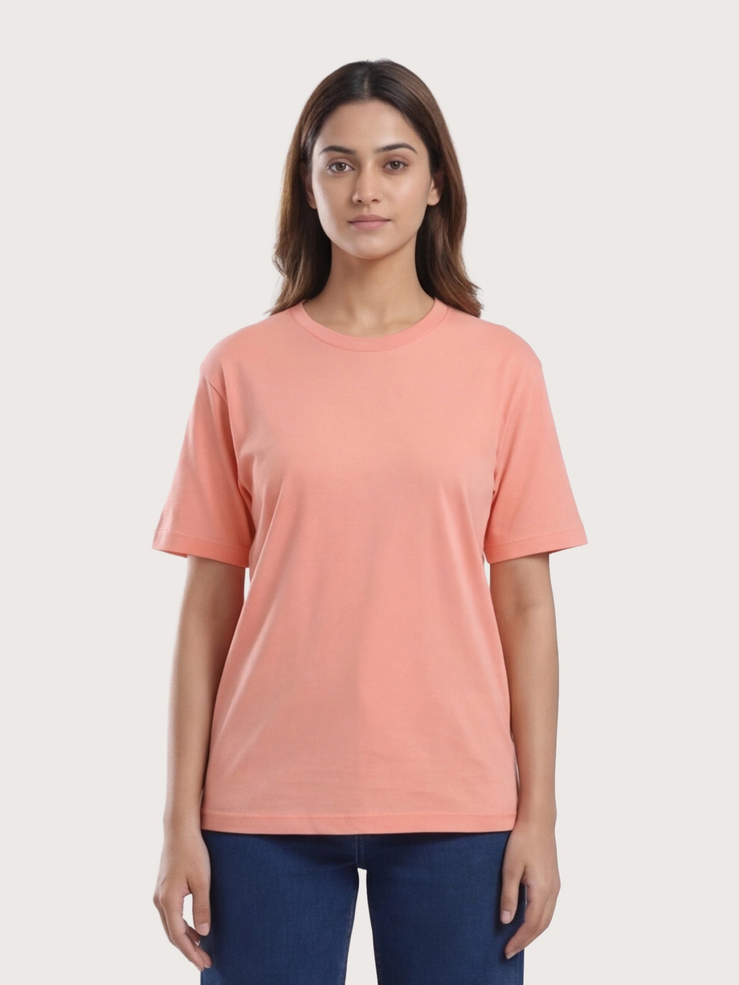 Woman wearing a peach-colored t-shirt against a white background
