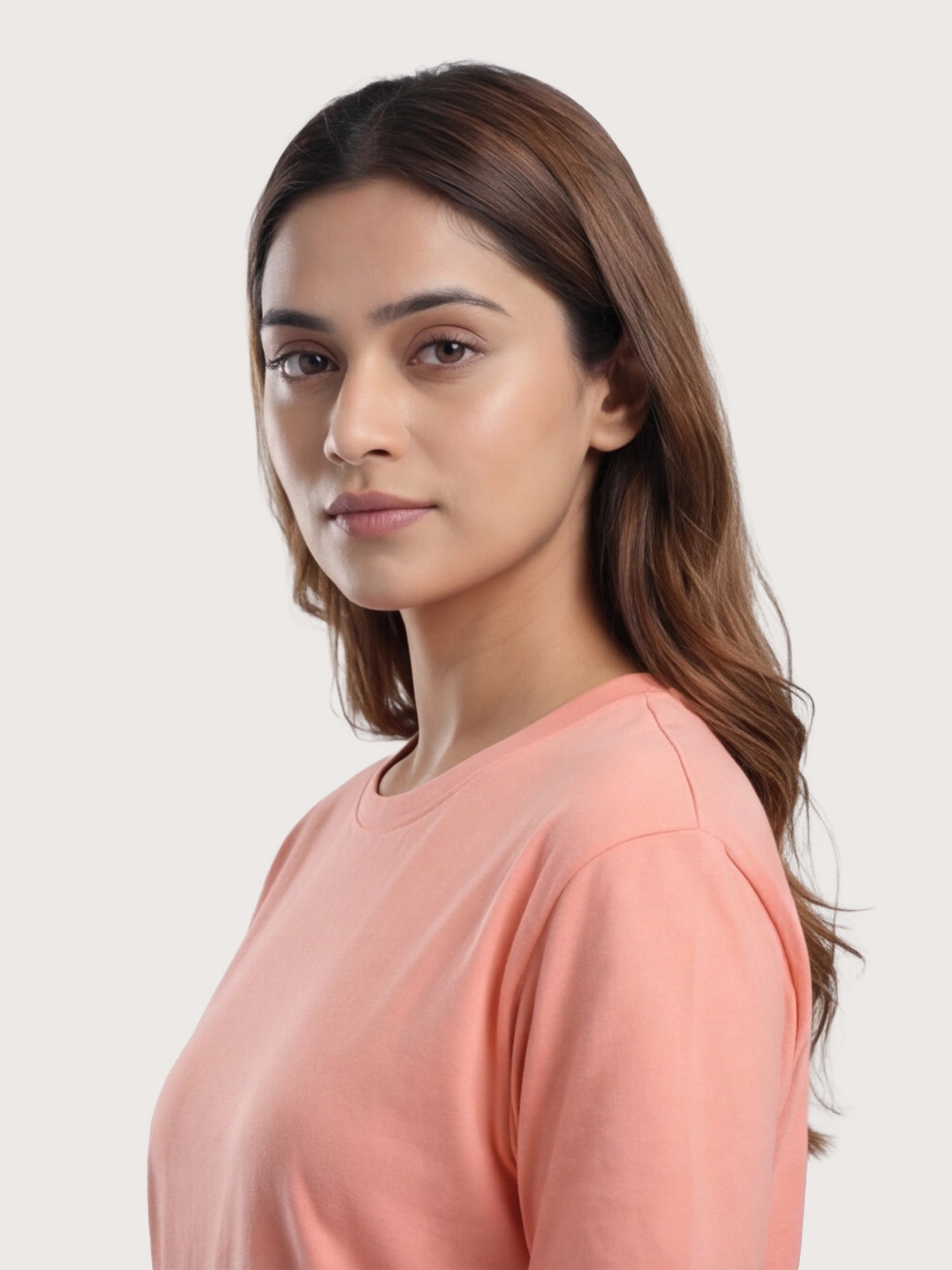 Woman wearing a peach-colored top against a plain background