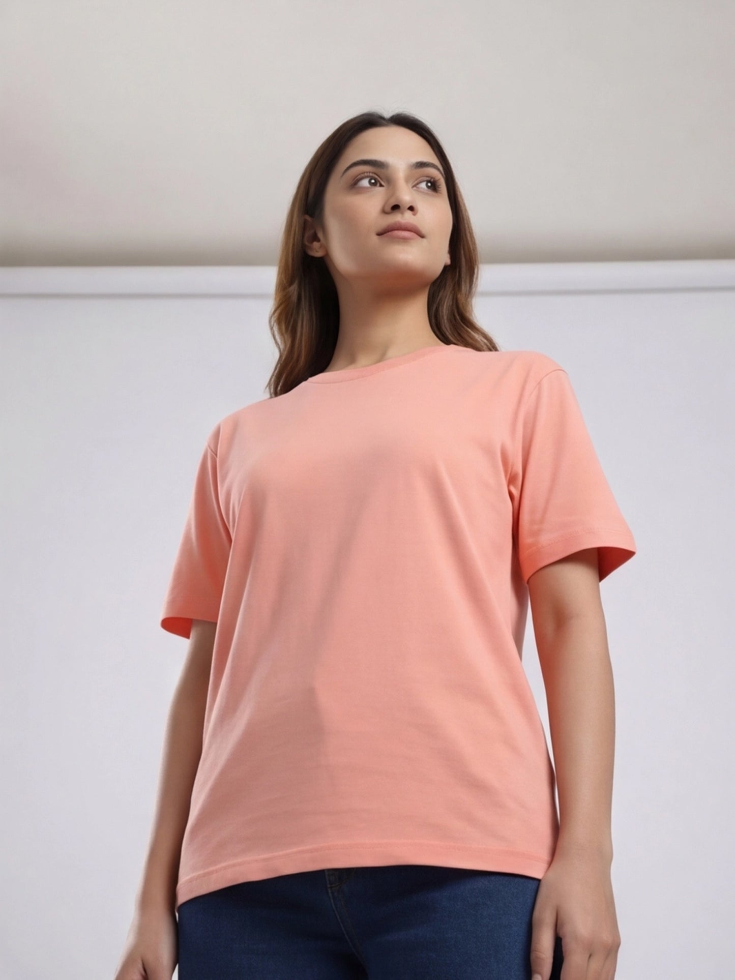 Woman wearing a peach-colored t-shirt against a plain background