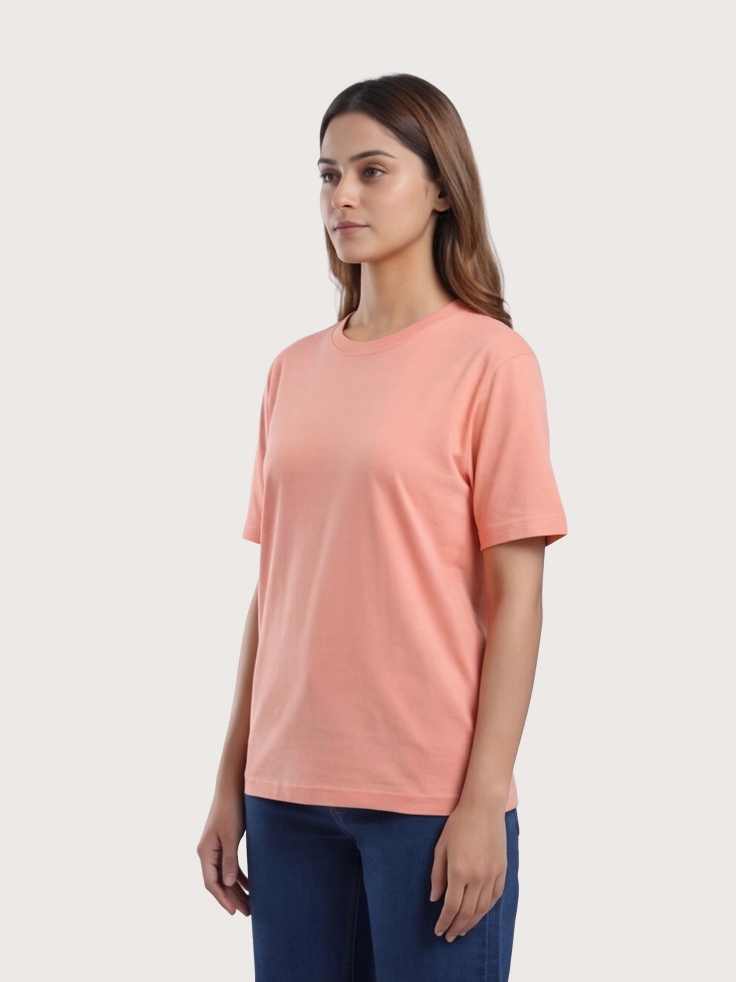 Woman wearing a peach-colored t-shirt against a plain background