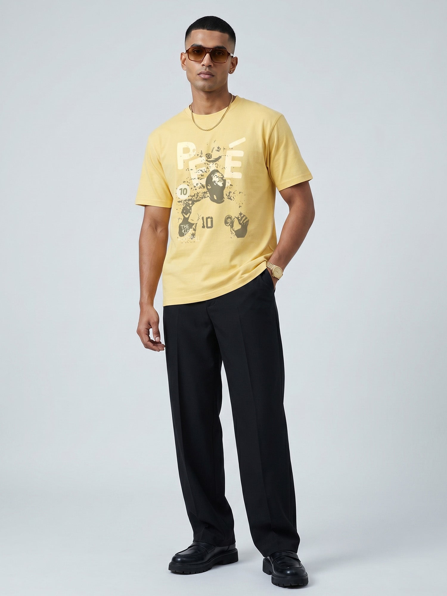 Man wearing a butter colour t-shirt with a graphic of PELÈ the footballer in it