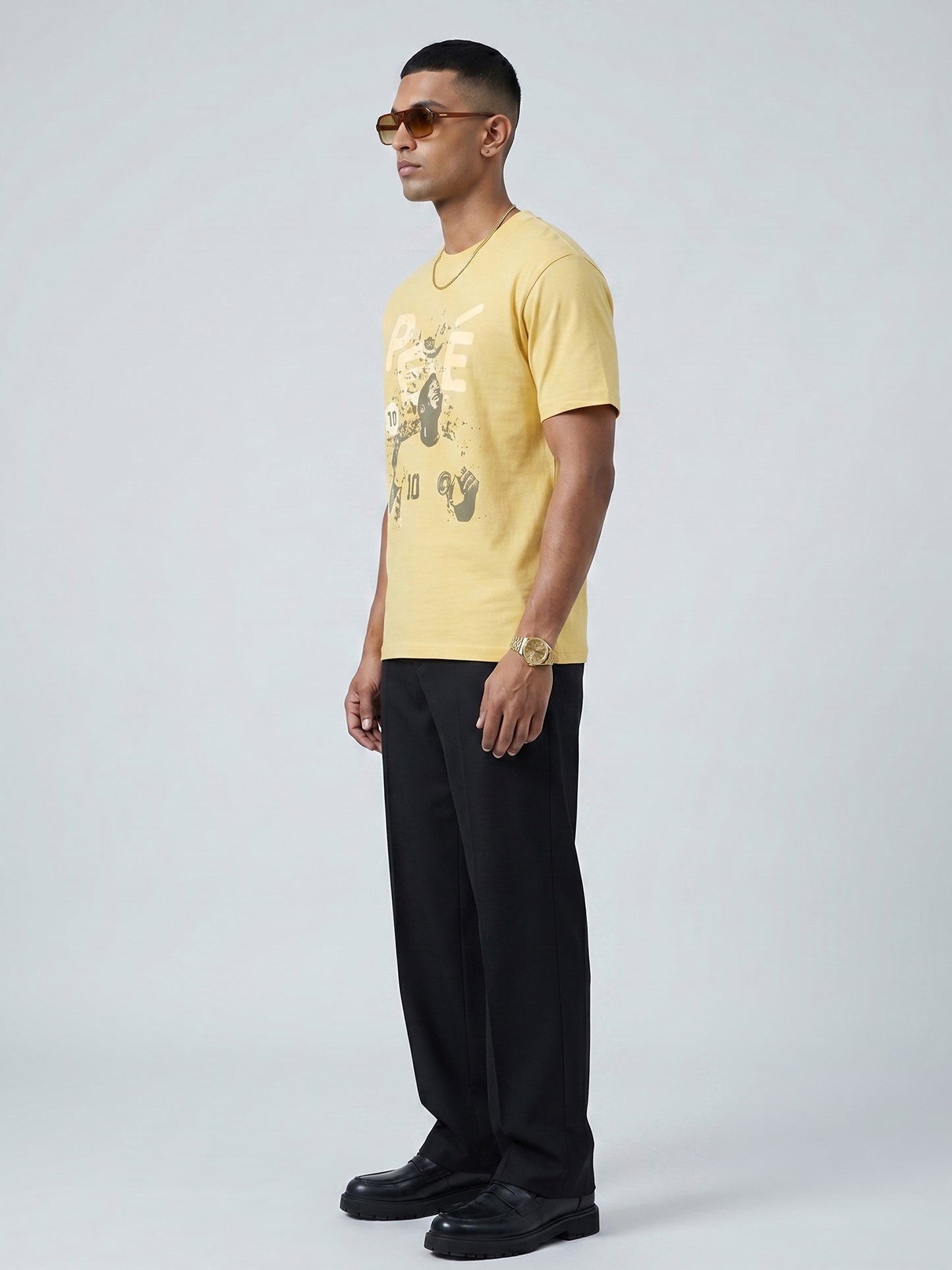 Man wearing a yellow butter colour t-shirt with a graphic of PELÈ the footballer in it