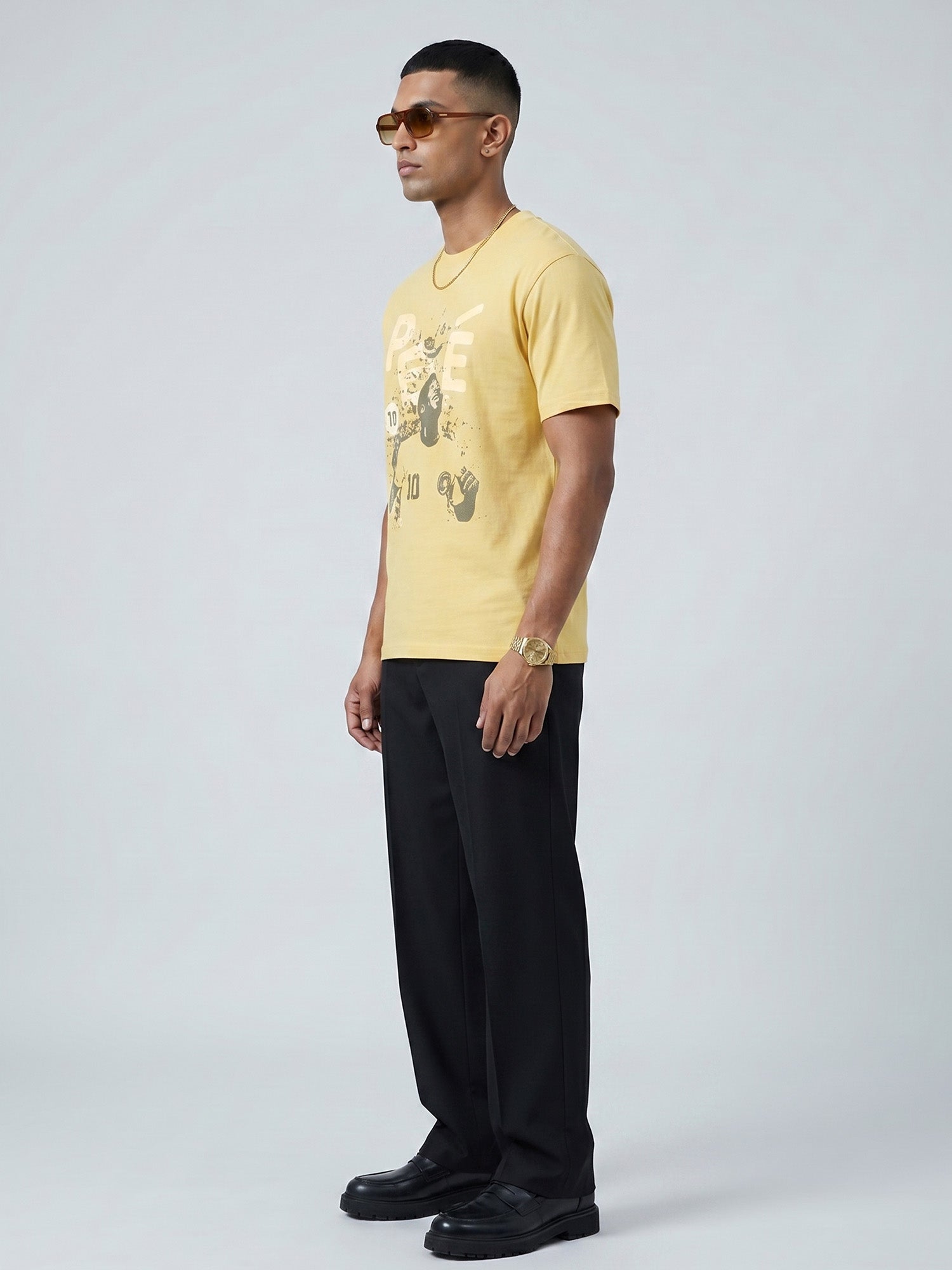 Man wearing a yellow butter colour t-shirt with a graphic of PELÈ the footballer in it