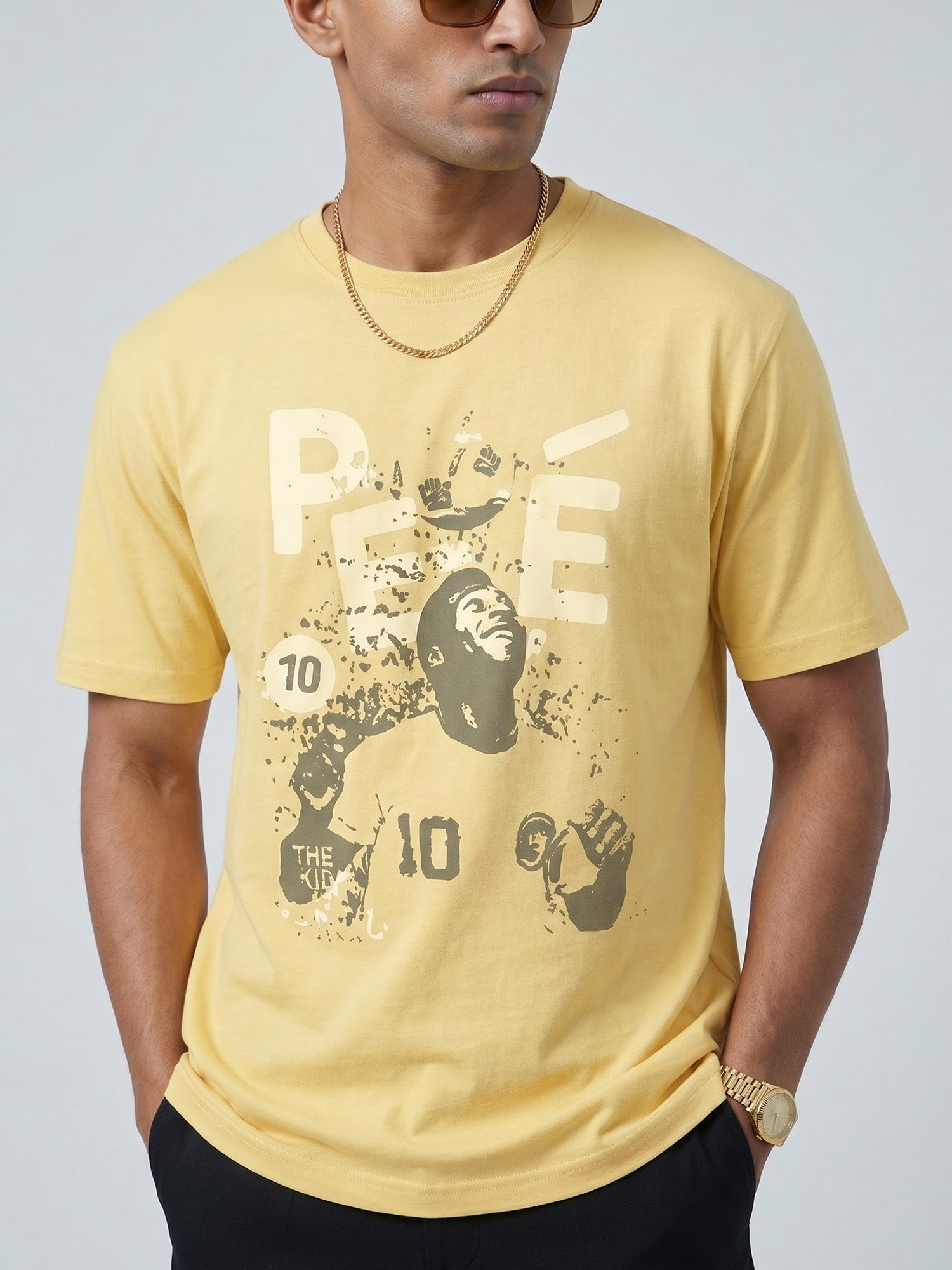 Man wearing a yellow butter colour t-shirt with a graphic of PELÈ the footballer in it