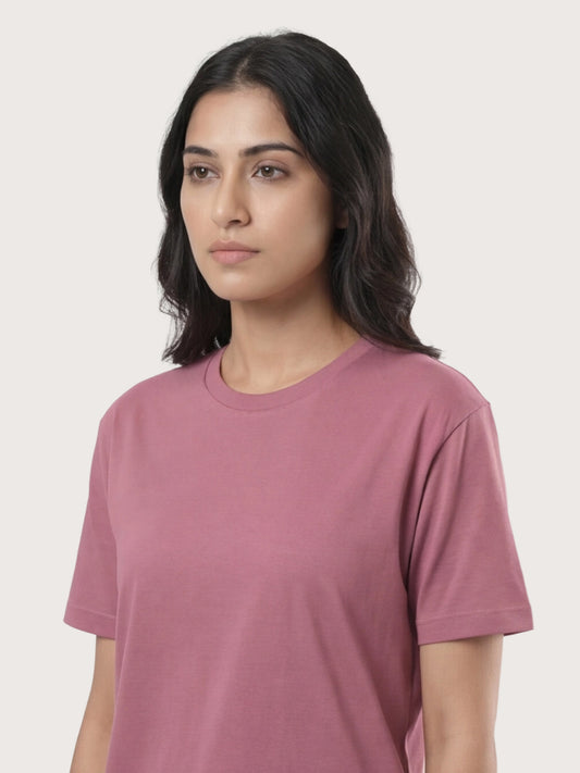 Woman wearing a mauve t-shirt against a plain background
