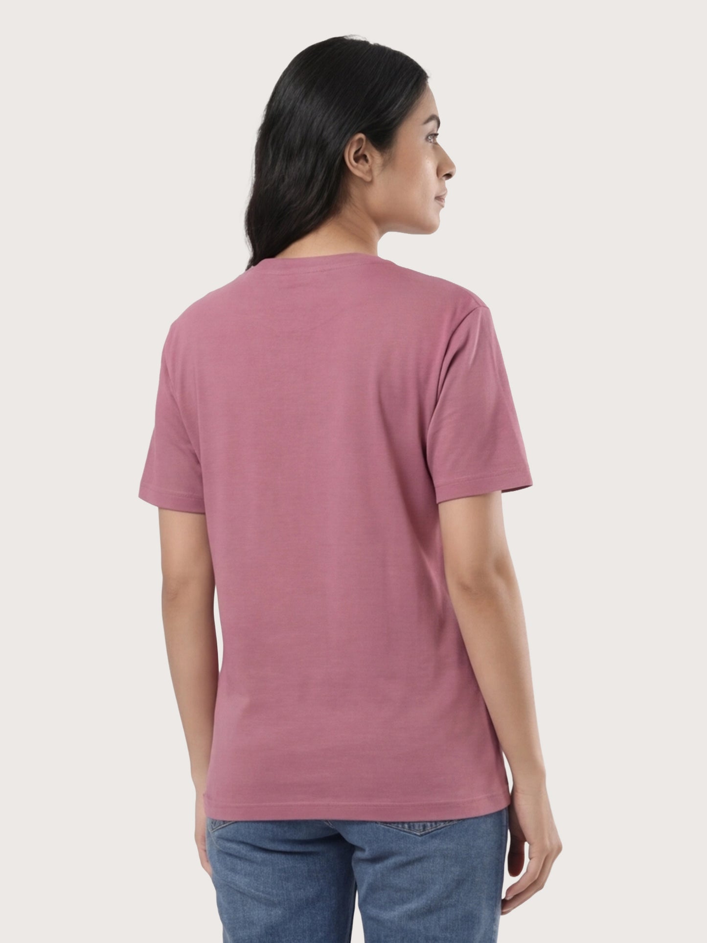Person wearing a pink t-shirt on a plain background