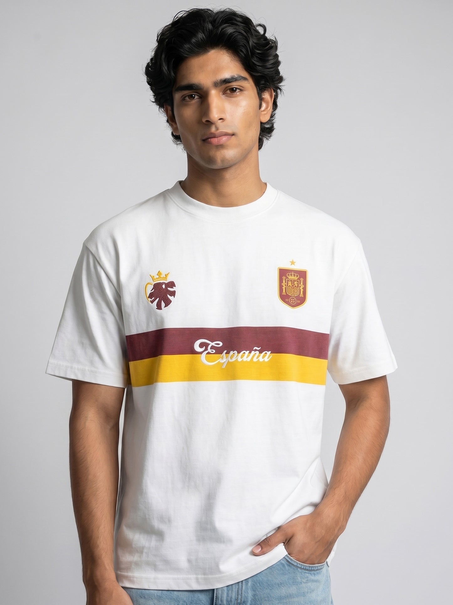 Person wearing a white t-shirt with Spanish-themed football jersey design on a grey background