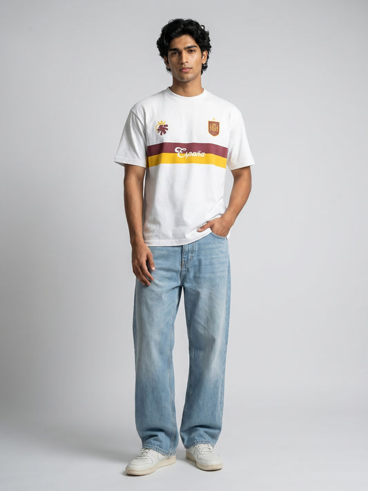Person wearing a white t-shirt with Spanish-themed football jersey design on a grey background