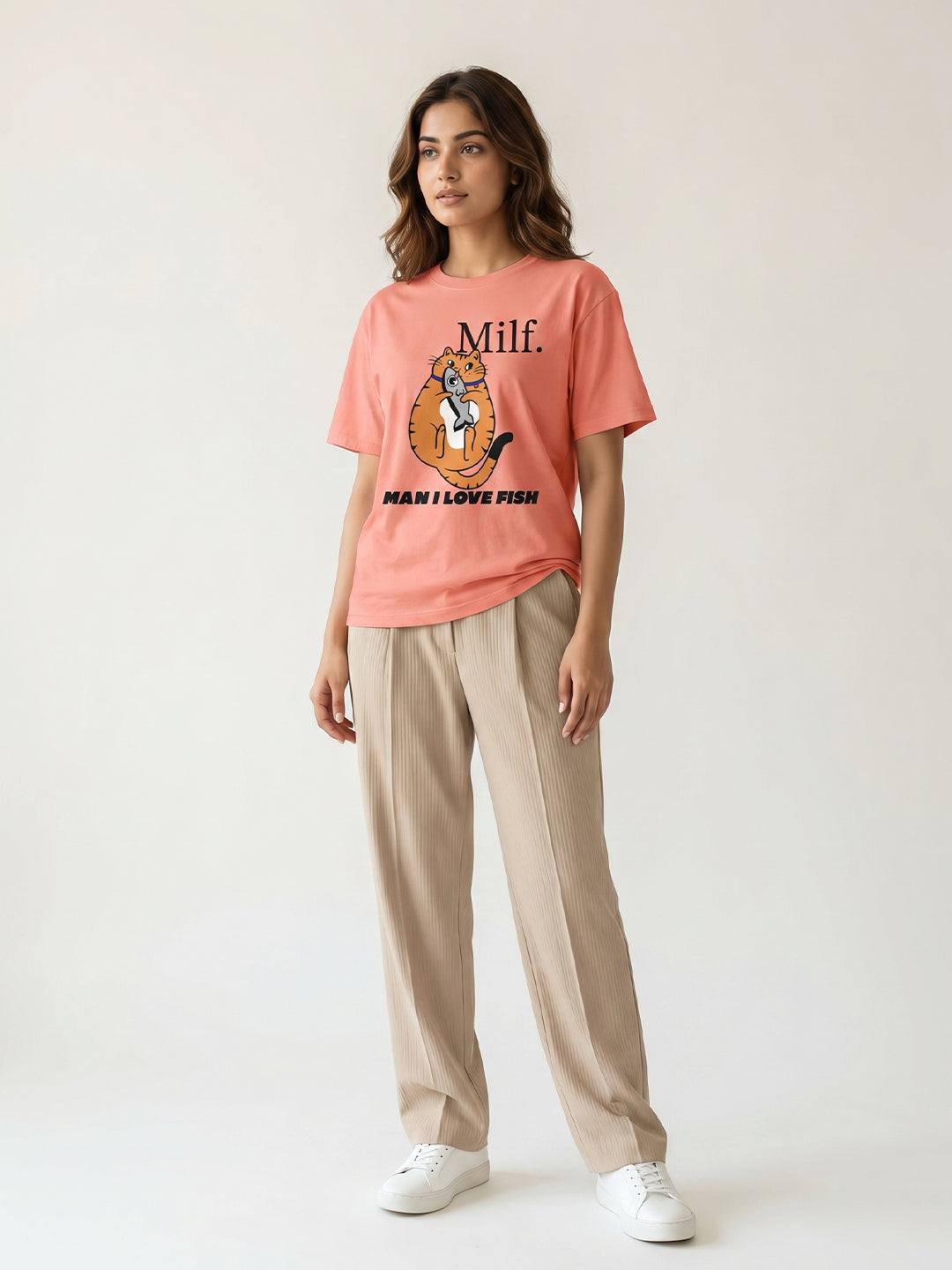 Woman wearing a peach t-shirt with graphic design, standing against a plain background